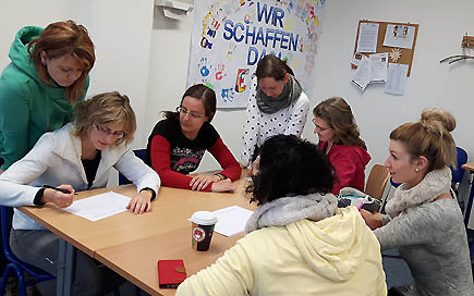DPFA Chemnitz Erzieherausbildung: Eine Gruppe von Lernenden sitz an einem Tisch udn arbeitet gemeinsam.