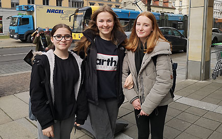 Drei angehende Sozialassistentinnen der DPFA Dresden stehen auf einer Straße in der Dresdner Neustadt und schauen in die Kamera.