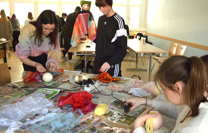 DPFA Zwickau Sozialassistentenausbildung Projekt Puppentheater: Mehrere Schülerinnen und Schüler arbeiten gemeinsam an ihren Puppen an einem Tisch.