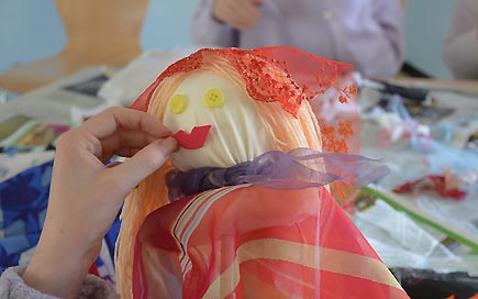 DPFA Zwickau Sozialassistentenausbildung Puppentheaterprojekt teaser: Eine Hand hält eine Puppe für ein Puppenthetaerstück